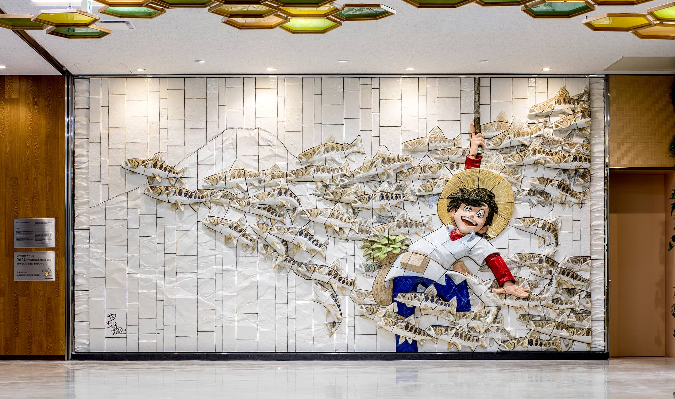 秋田空港に設置された陶板レリーフ作品「釣りキチ三平・山魚女群泳」全景