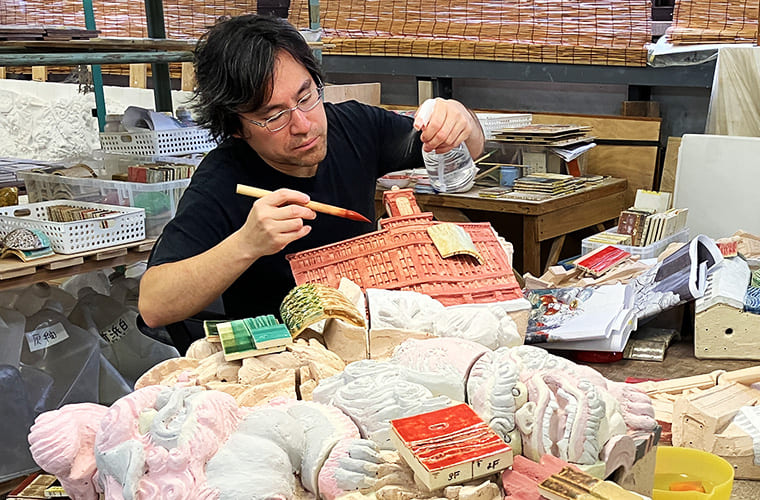 Applying glaze individually to each piece of the Ceramic Relief