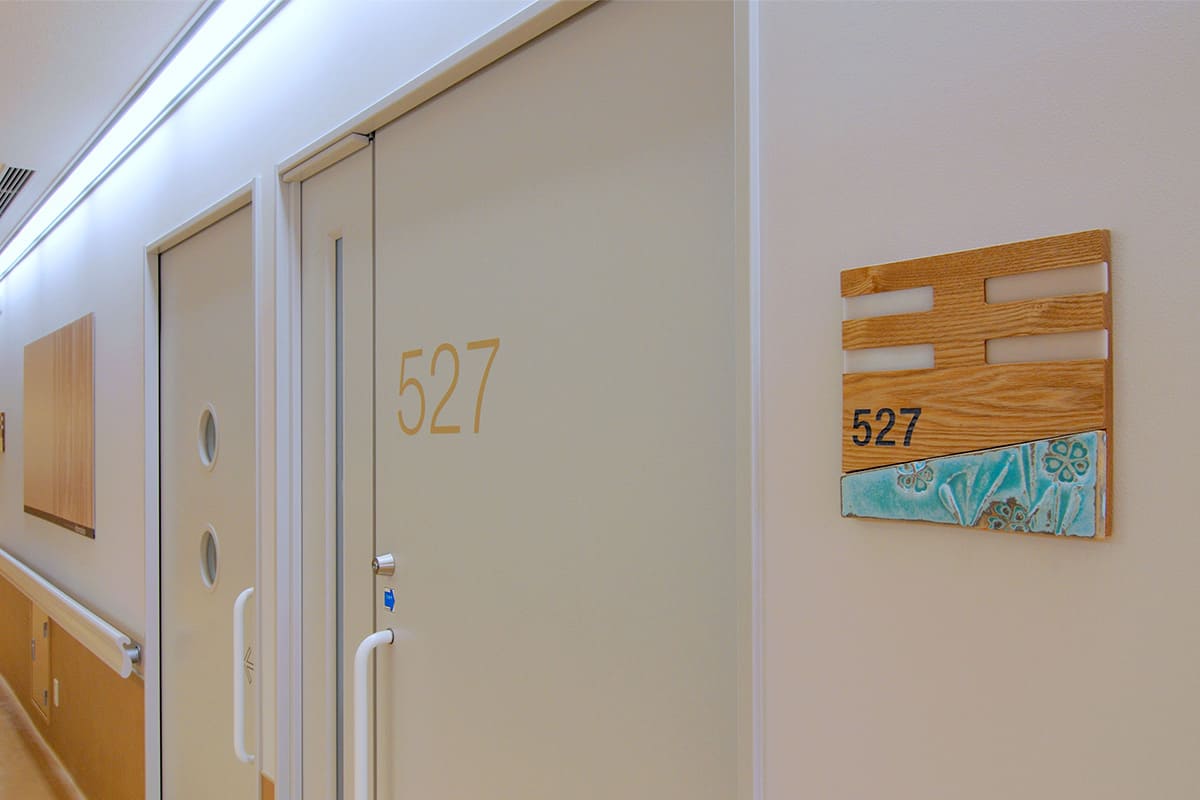 A ceramic room-number sign installed in a hospital