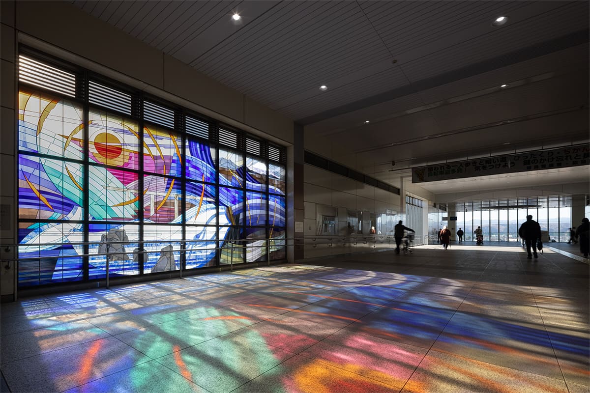 The Stained Glass artwork “Beautiful water flow, dream in the blowing wind : FUSSA / AKISHIMA” and the surrounding station environment at Haijima Station